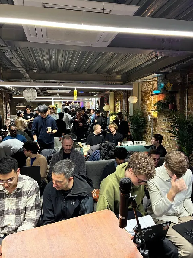 A crowded room of hackathon participants gathered for a talk